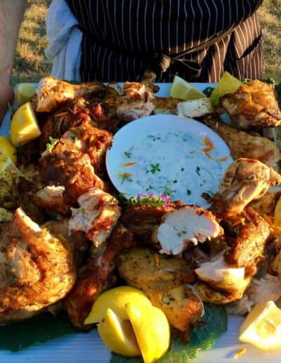 Grilled chicken being served on a platter