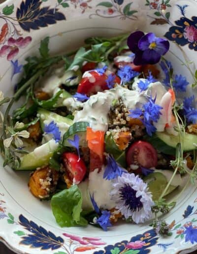 Quinoa bowl with seasonal vegetables and edible flowers.